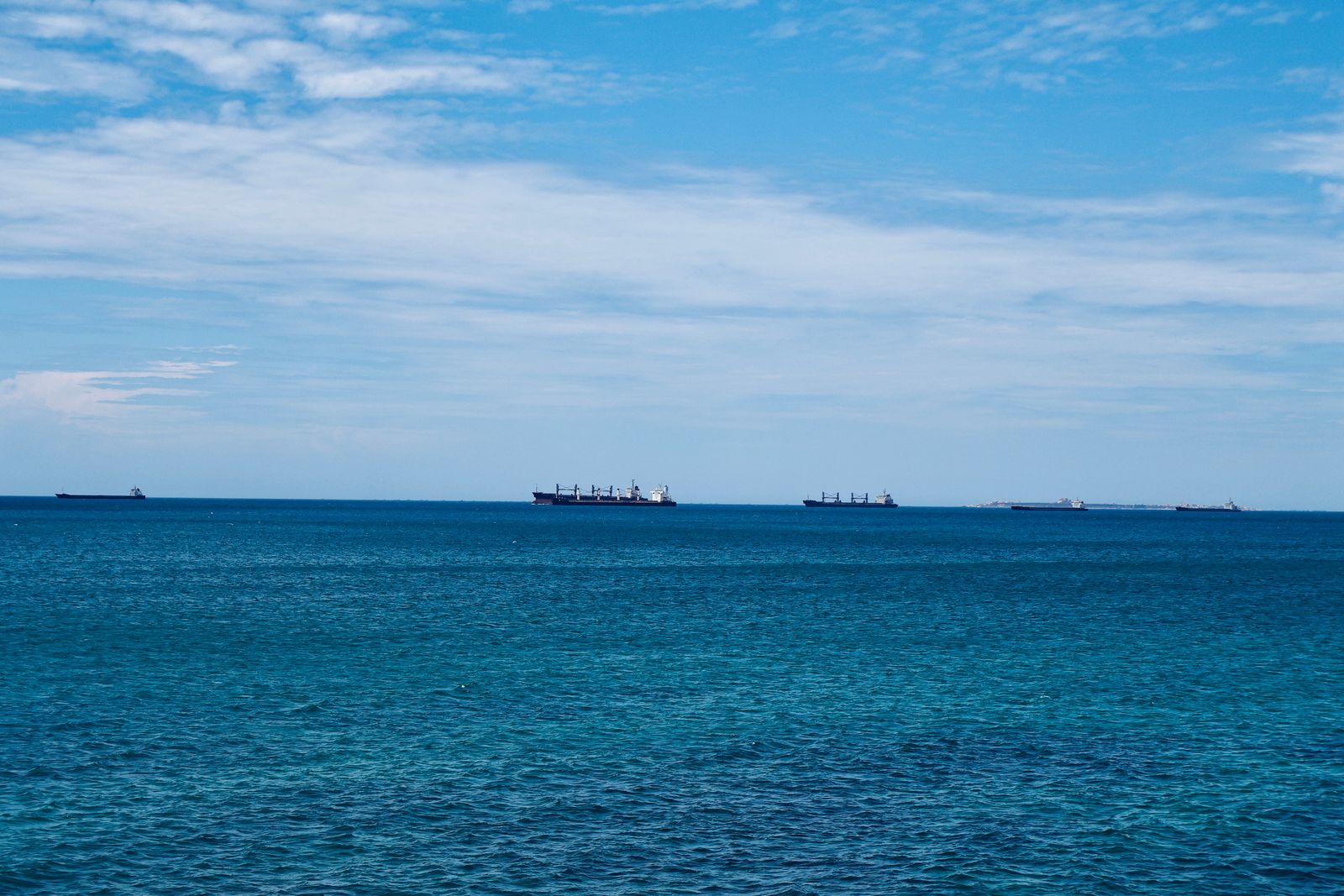 Plusieurs navires de charge mouillant au large sous un ciel dégagé