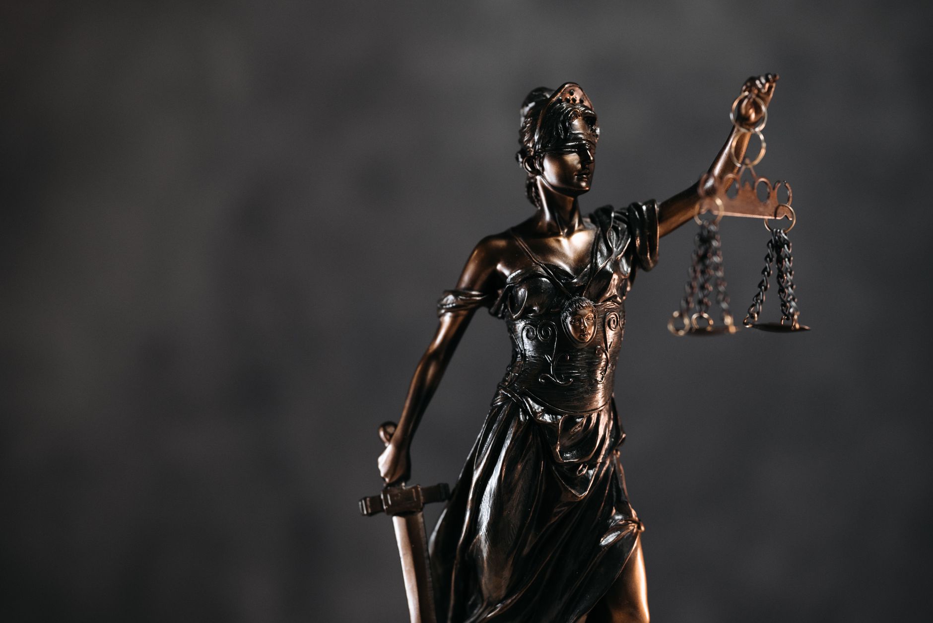 Statuette de la Justice tenant sa balance, sur fond sombre