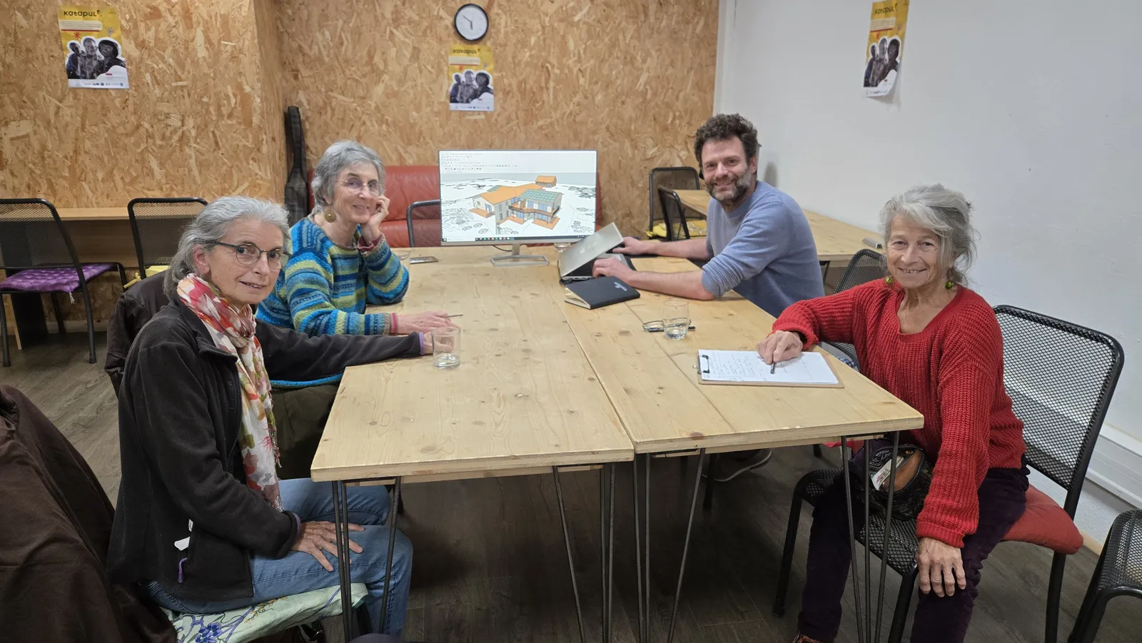 Séance de travail avec des membres de l’habitat participatif Aygue Mazel, autour d’une table, la maquette numérique du projet à l’écran