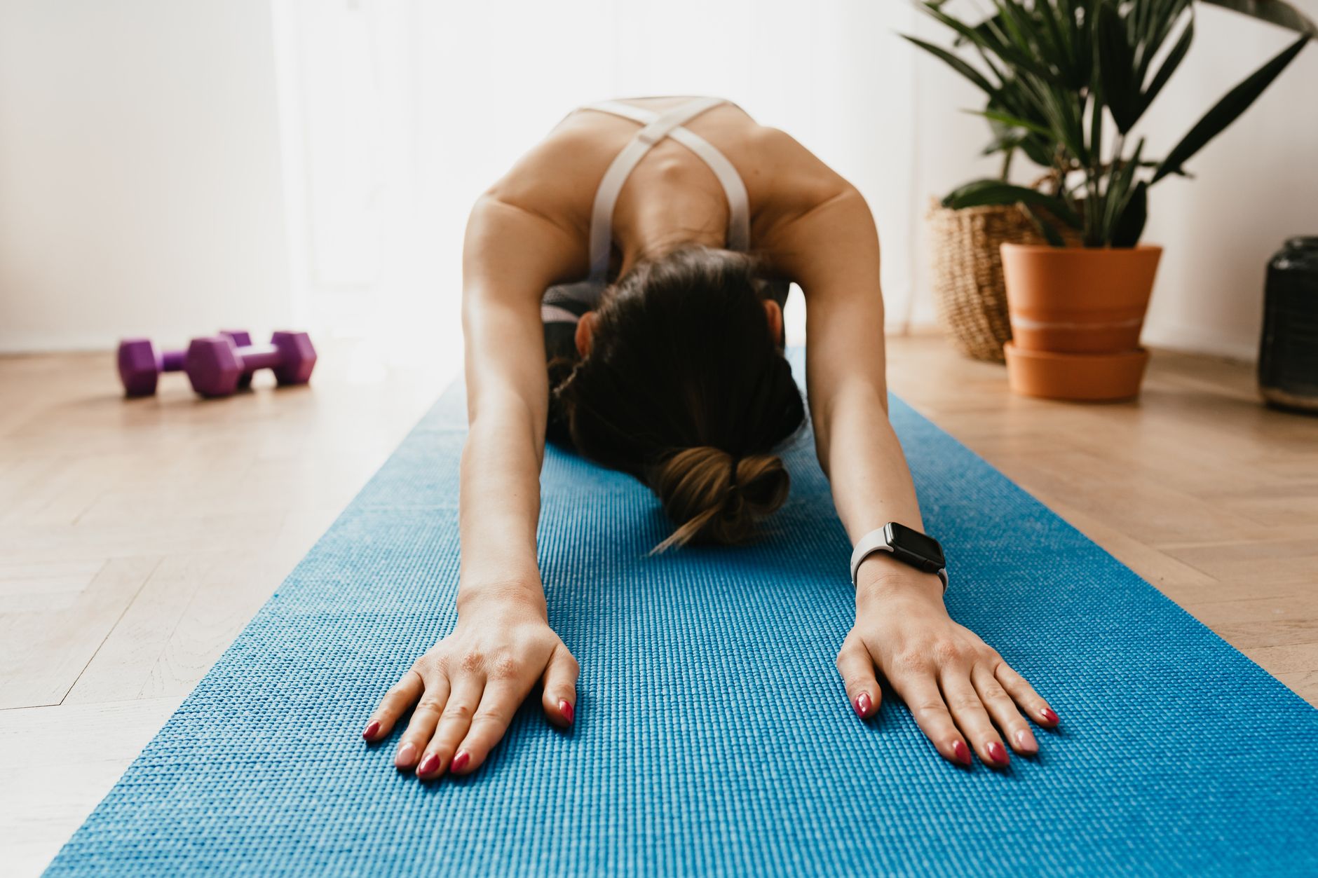Femme d’âge moyen pratiquant le yoga à la maison, illustrant le bien-être au quotidien