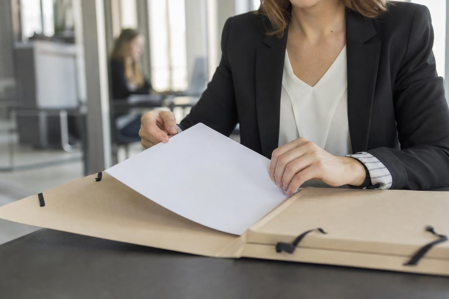 Dossier de saisie immobilière examiné sur un bureau par une justiciable.